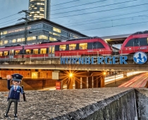 #mobilität_erleben, Playmobilmännchen vor der Kulisse des Bahnhofs Ostring, Foto Robert Hackner / Stadt Nürnberg