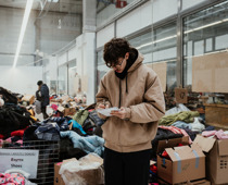 Linus (Schüler des HLG, junger Aktivist des Frankenkonvoi) notiert Bedarfs-Listen in einer spontan zum Hilfsgüter-Verteil-Zentrum umgerüsteten Shopping-Mall an der polnisch-ukrainischen Grenze. Polen, 2022