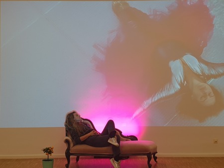 Bogi Nagy: „Bogi auf der Chaisselongue vor der Projektion eines Performance-Videos © Ida Hinterholzinger“